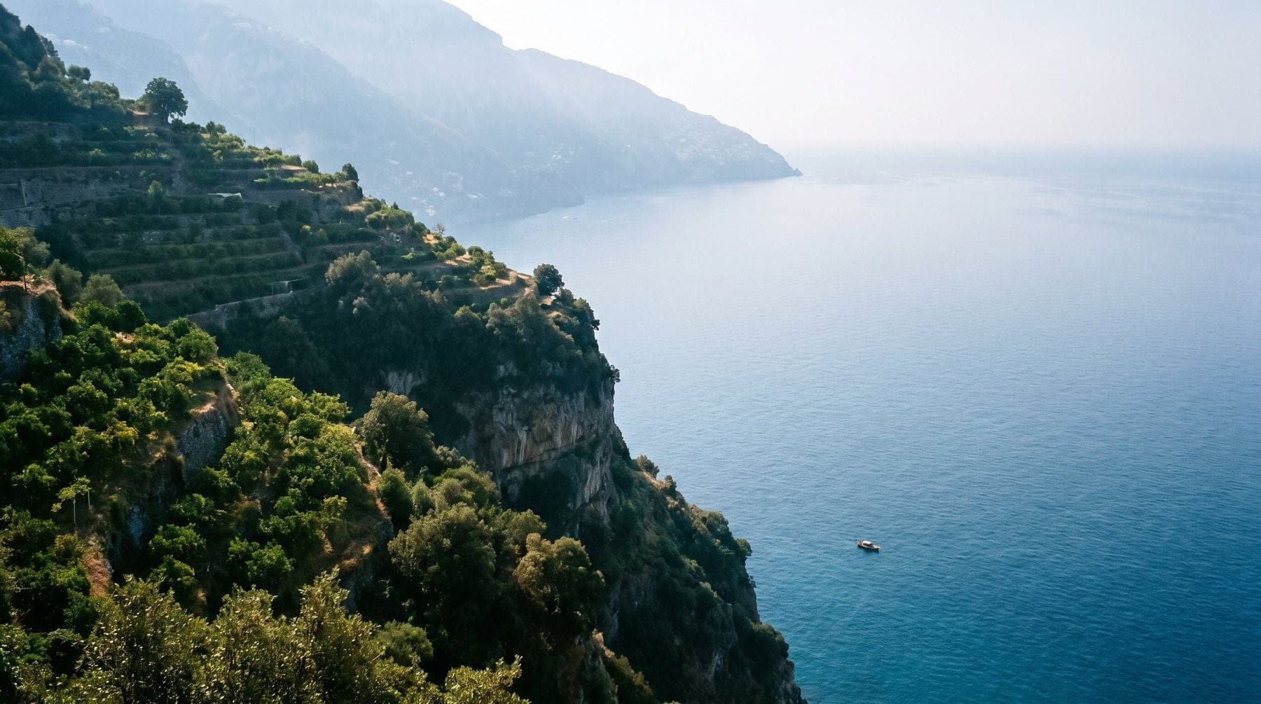 Pastel houses stacked on a steep cliff above the sea on the Amalfi Coast