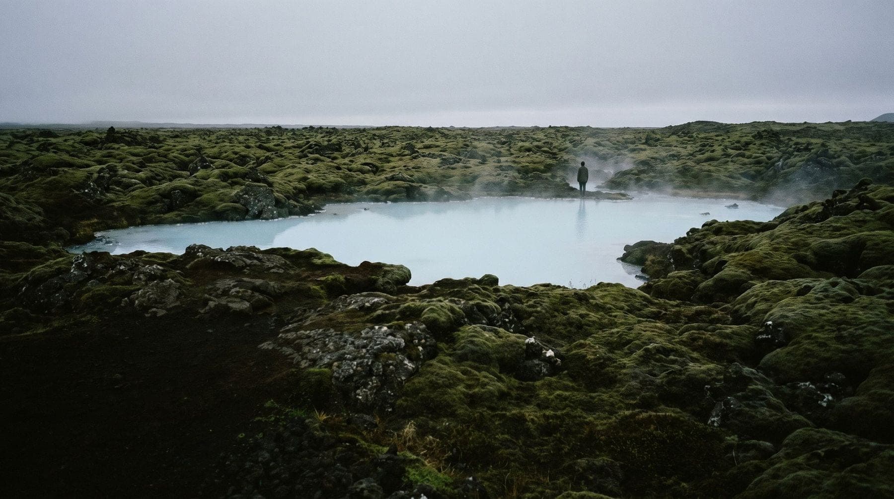 A moss-covered lava field around milky blue geothermal water on the Reykjanes peninsula