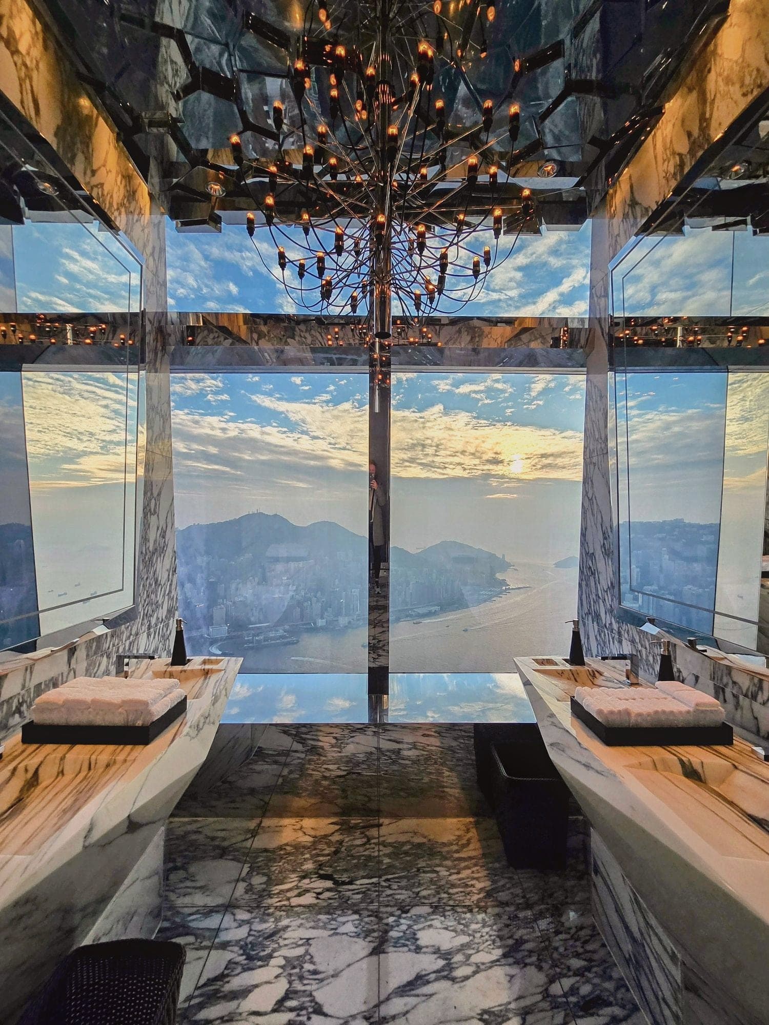 A marble washroom with floor-to-ceiling windows high above Victoria Harbour, Hong Kong.