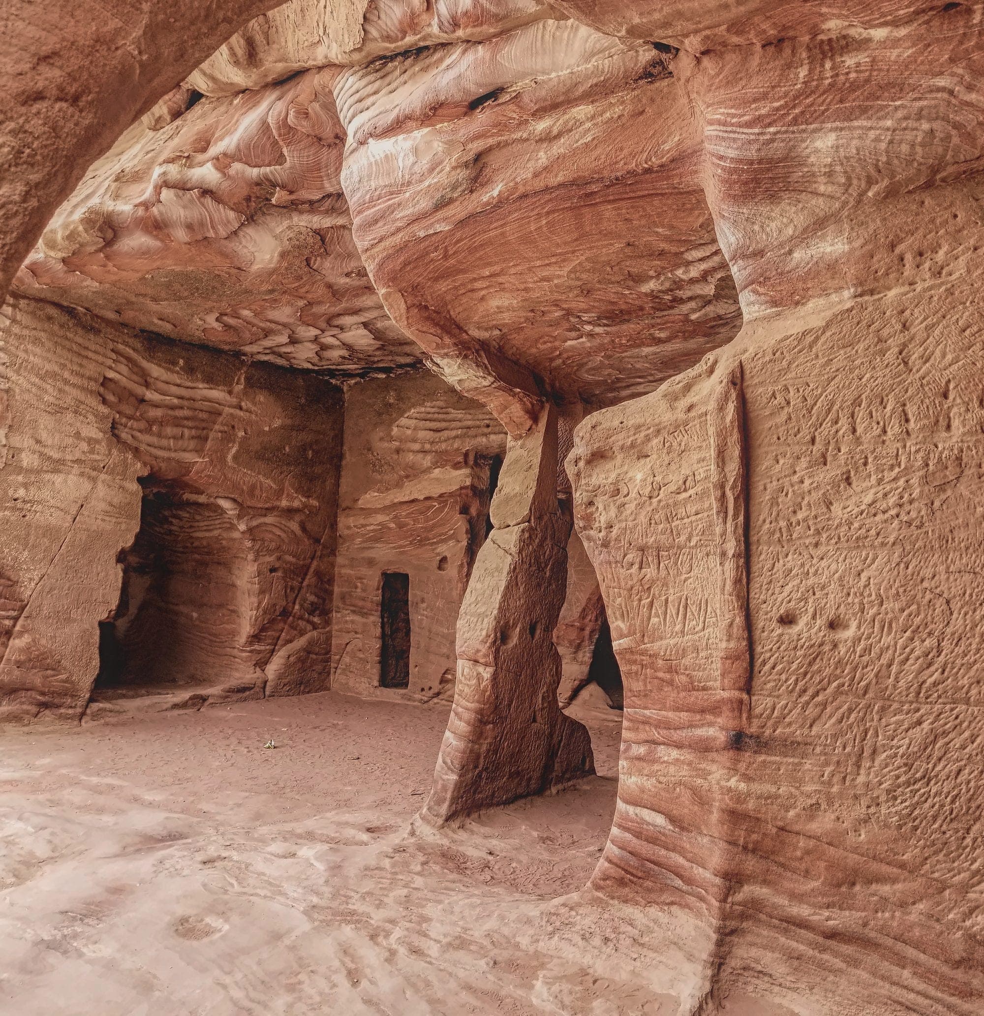 A carved tomb chamber in swirled red and cream sandstone, Petra