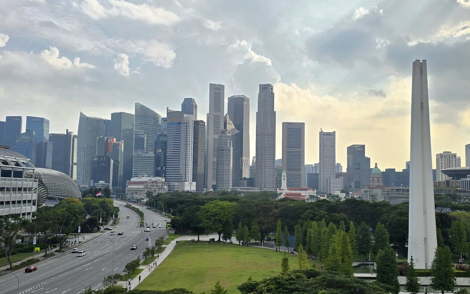 The towers of central Singapore across green parkland under a big sky