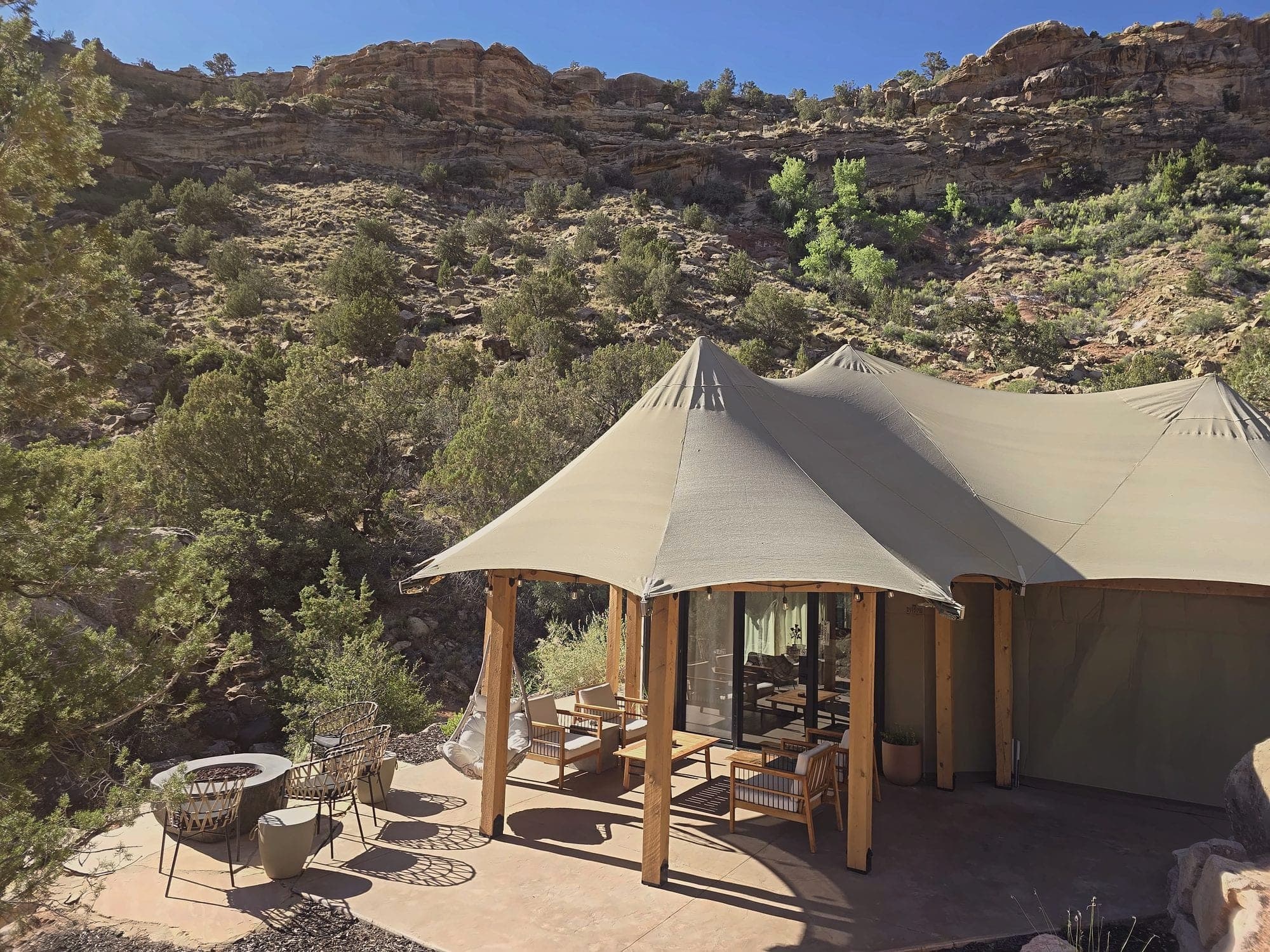 A canvas suite tent and patio beneath red cliffs near Zion