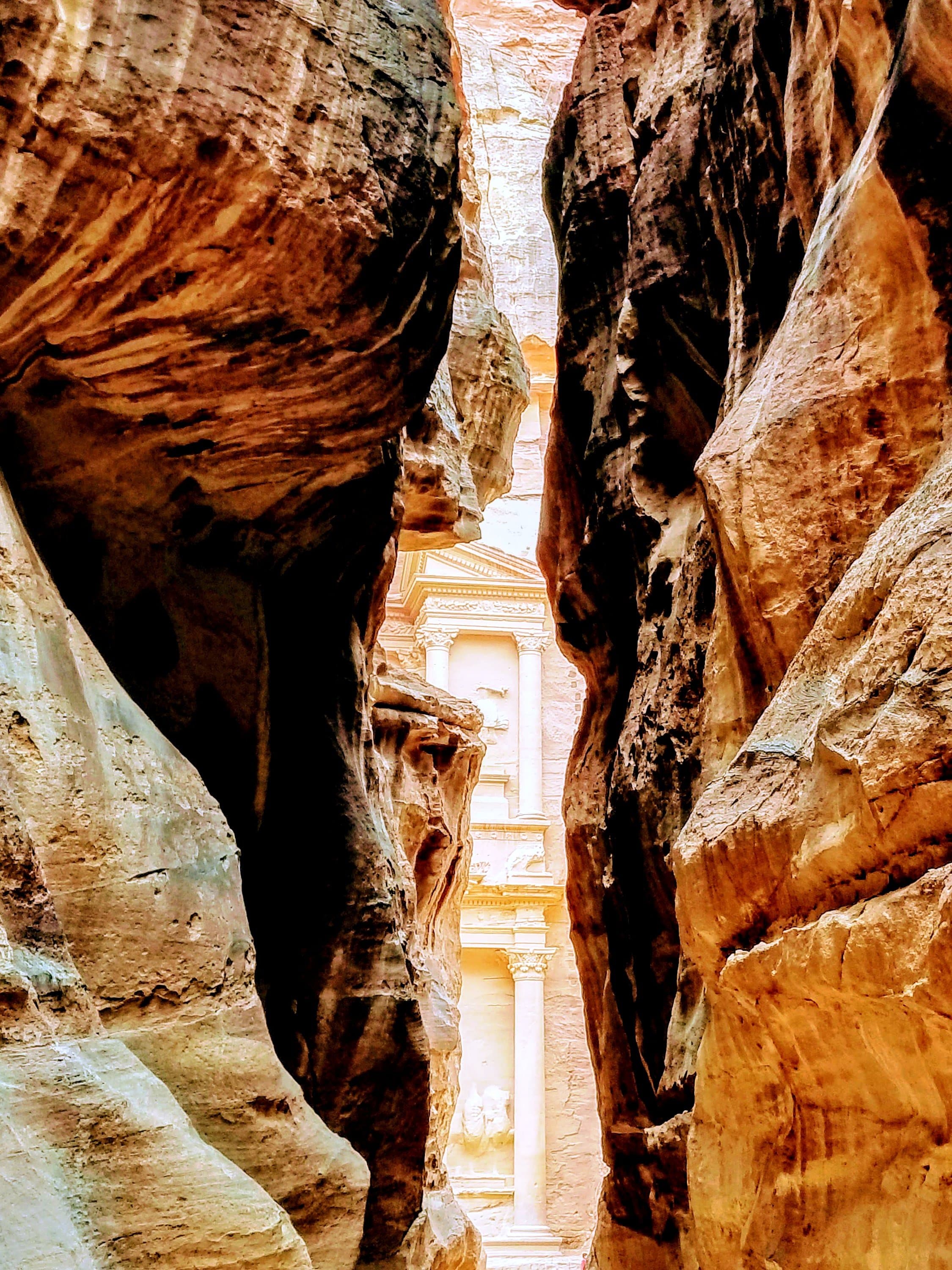 The first glimpse of the Treasury through the narrow walls of the Siq, Petra